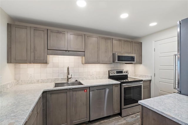 1051 Beach Blvd W Unit 9B, Gulf Shores, AL 36542 - kitchen with appliances with stainless steel finishes, light wood-style flooring, tasteful backsplash, light countertops, and recessed lighting