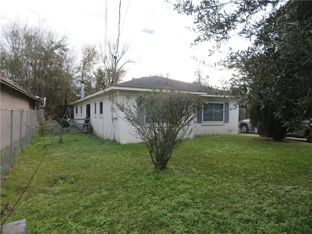 view of side of home with a lawn