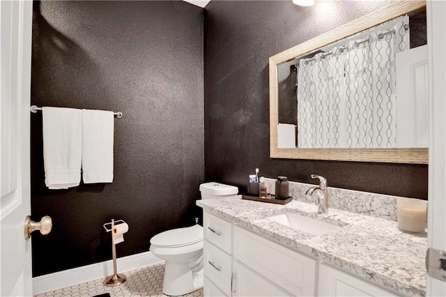 bathroom featuring vanity, toilet, and tile patterned flooring