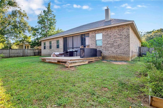 rear view of house with a wooden deck, central AC, and a lawn