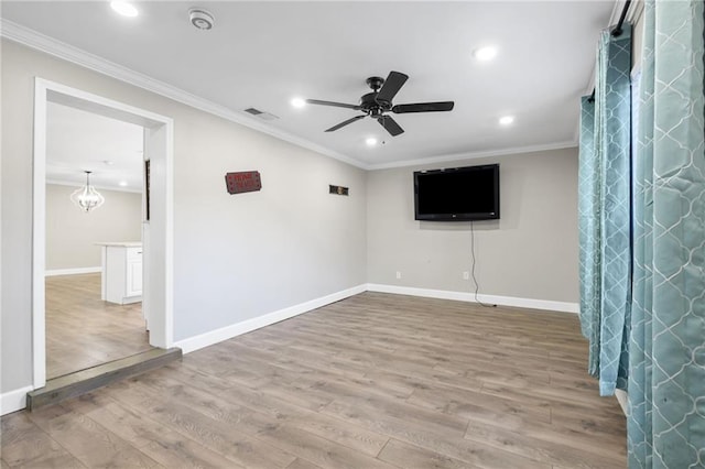 interior space with ceiling fan with notable chandelier, wood-type flooring, and ornamental molding