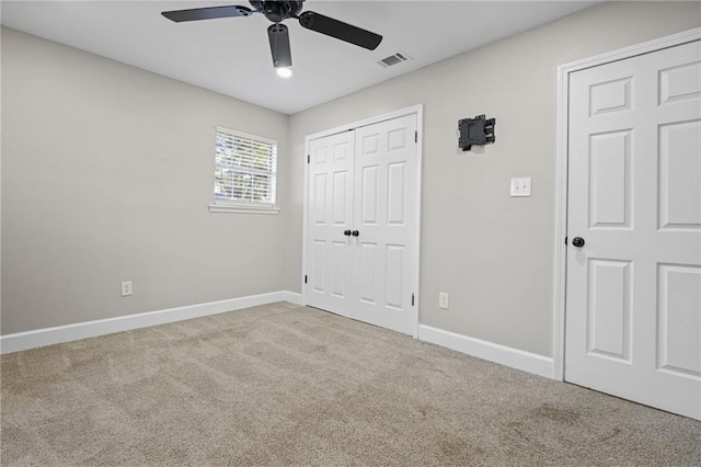 unfurnished bedroom with ceiling fan, light carpet, and a closet