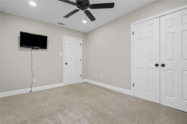 unfurnished bedroom with light carpet, a closet, and ceiling fan