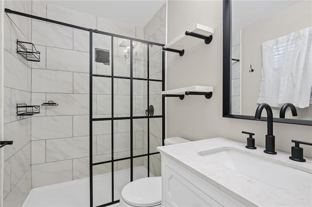 bathroom featuring vanity, toilet, and tiled shower