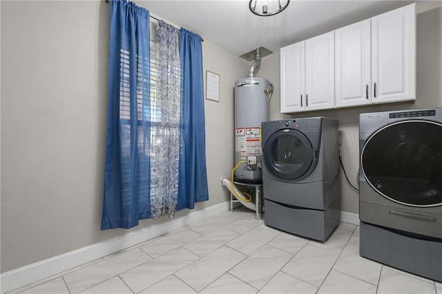 laundry area with washing machine and dryer, cabinets, and gas water heater