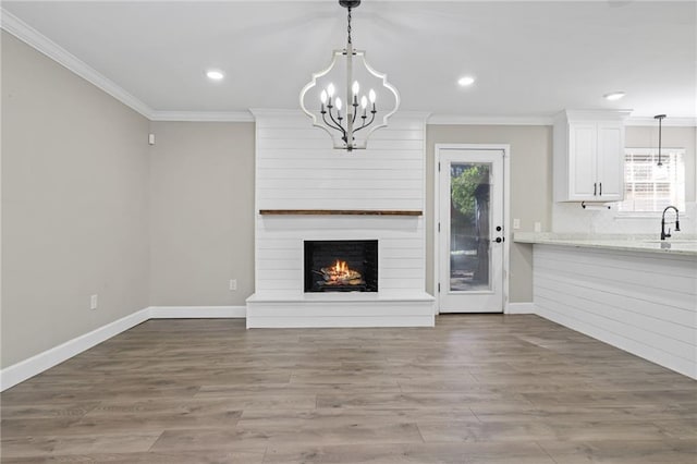 unfurnished living room with a fireplace, wood-type flooring, plenty of natural light, and crown molding