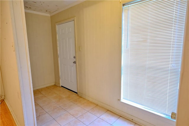 empty room with light tile patterned floors and crown molding