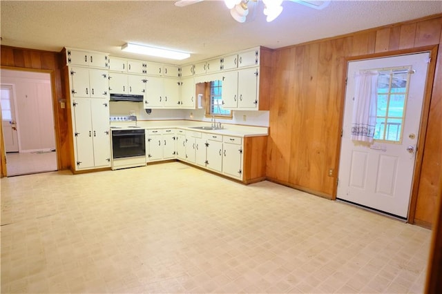 kitchen with ceiling fan, electric stove, light tile patterned floors, and a wealth of natural light