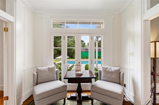 sitting room with crown molding, wood-type flooring, and french doors