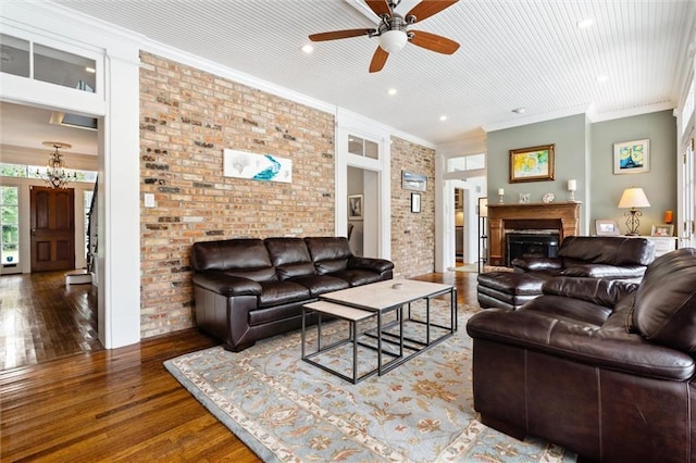 living room with crown molding, ceiling fan, brick wall, and dark hardwood / wood-style flooring