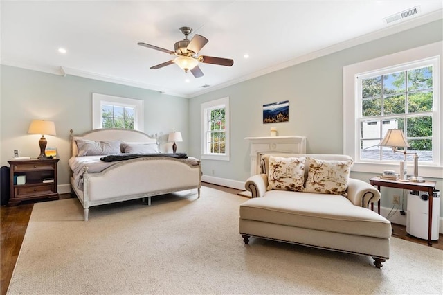 bedroom featuring ceiling fan, ornamental molding, and multiple windows