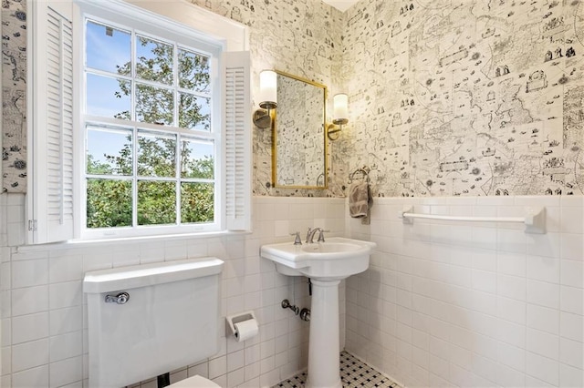 bathroom featuring tile walls and toilet