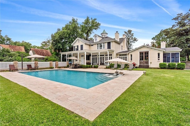 view of swimming pool featuring a patio area and a lawn