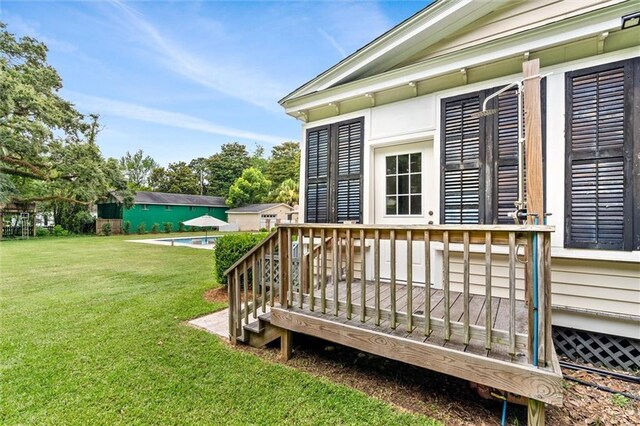 wooden terrace featuring a yard and a swimming pool