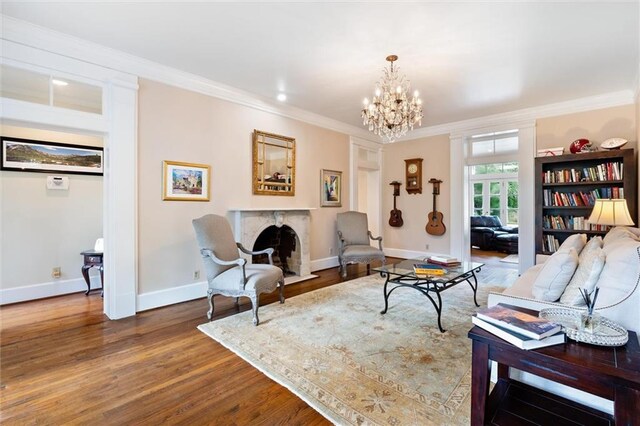 sitting room featuring crown molding, hardwood / wood-style floors, a notable chandelier, and a high end fireplace