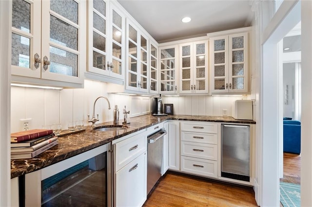 kitchen featuring wine cooler, sink, dark stone countertops, fridge, and white cabinets