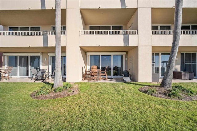 rear view of house with a yard and a patio