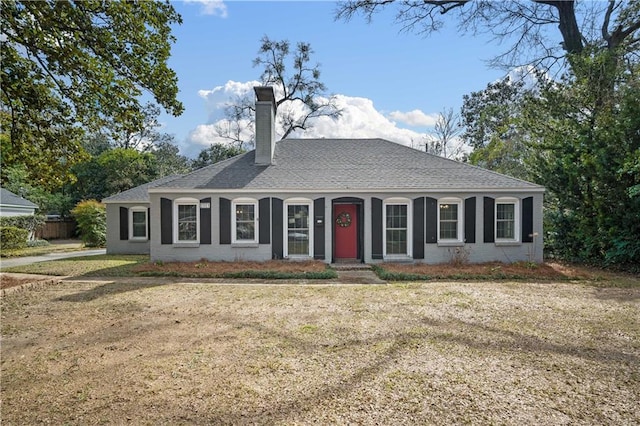 single story home with a shingled roof and a chimney