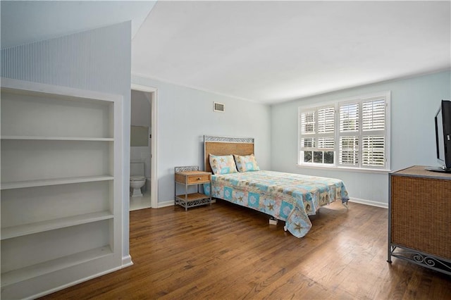 bedroom with baseboards, visible vents, and wood finished floors