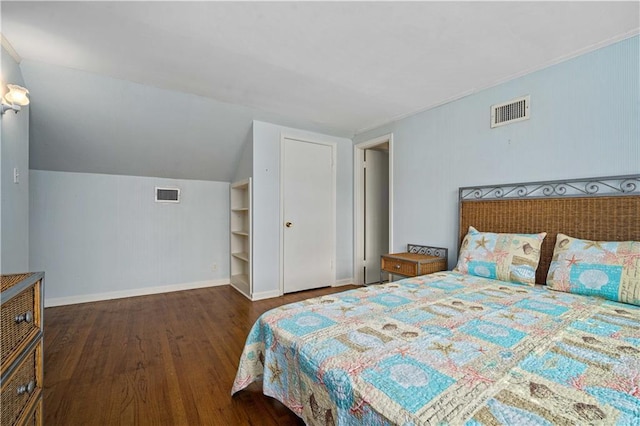 bedroom with vaulted ceiling, wood finished floors, visible vents, and baseboards