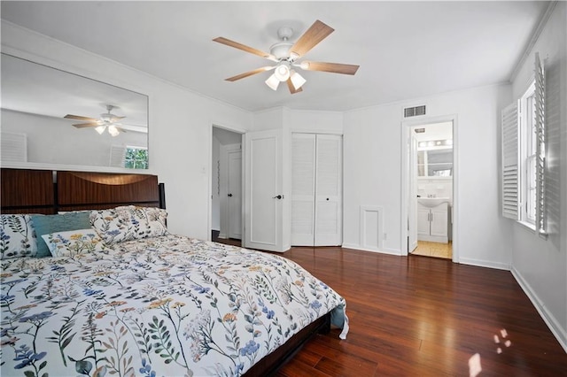 bedroom with ensuite bathroom, wood finished floors, a ceiling fan, visible vents, and baseboards