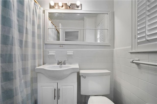 full bathroom featuring toilet, curtained shower, tile walls, and vanity