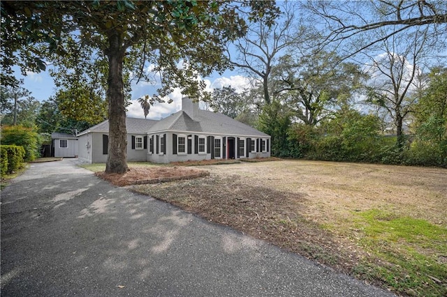 view of front of home with driveway and a chimney