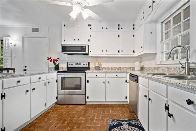 kitchen featuring stainless steel appliances, visible vents, backsplash, a sink, and plenty of natural light