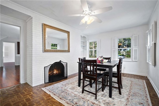 dining room featuring brick floor, a fireplace, baseboards, and crown molding