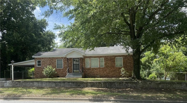 ranch-style house featuring a carport, crawl space, brick siding, and fence