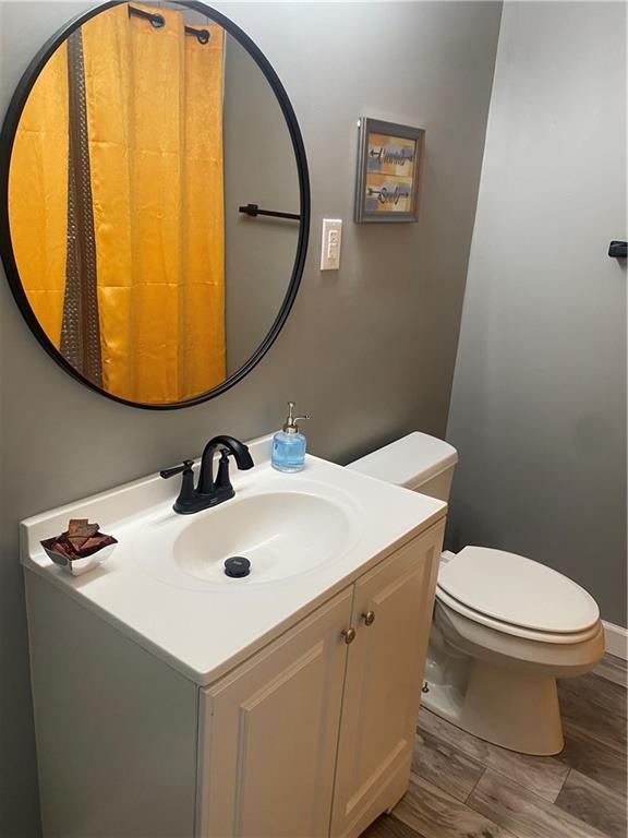 bathroom featuring vanity, toilet, and wood finished floors