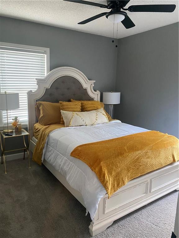 bedroom with carpet, ceiling fan, and a textured ceiling