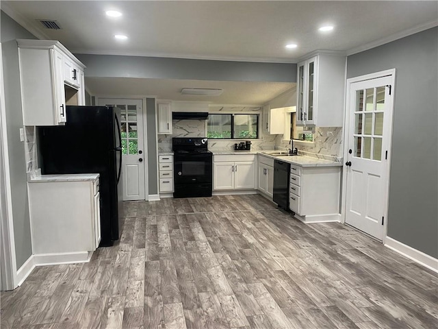 kitchen featuring backsplash, black appliances, white cabinets, sink, and wood-type flooring