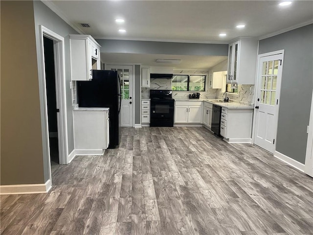 kitchen with ornamental molding, a sink, black appliances, and wood finished floors