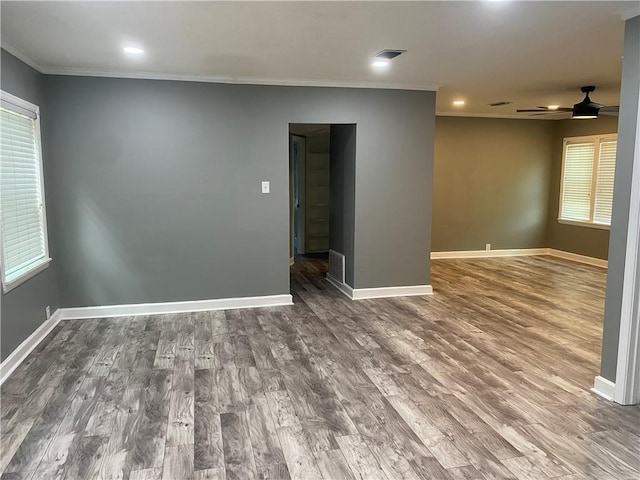 spare room with baseboards and wood finished floors