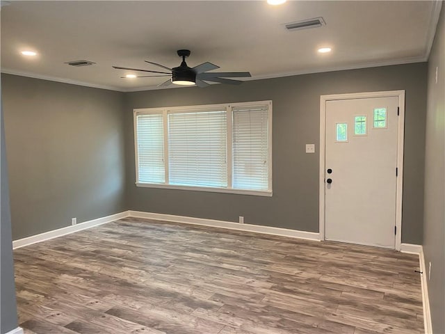 foyer entrance featuring a healthy amount of sunlight, crown molding, ceiling fan, and wood-type flooring