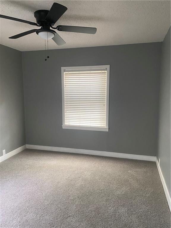 spare room featuring carpet floors, a ceiling fan, baseboards, and a textured ceiling