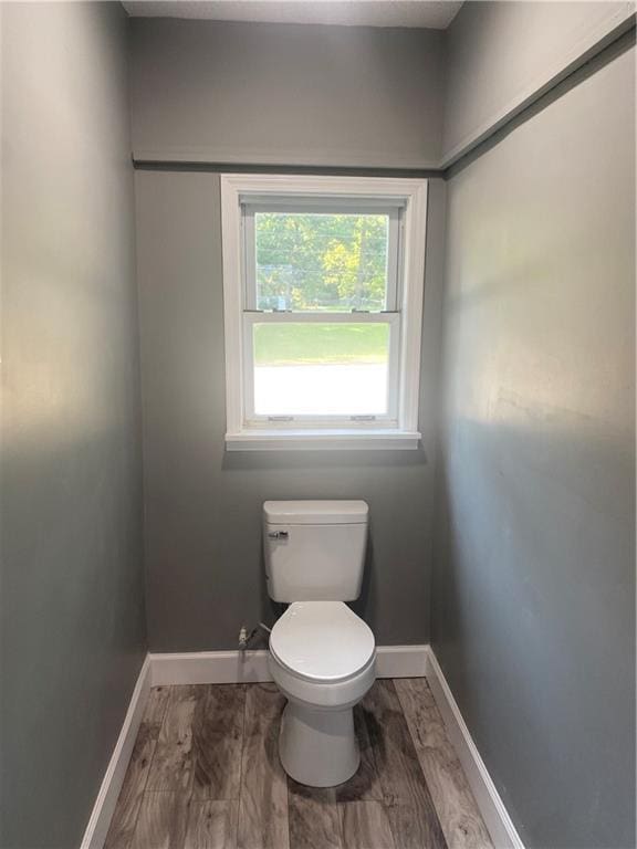 bathroom featuring baseboards, toilet, and wood finished floors