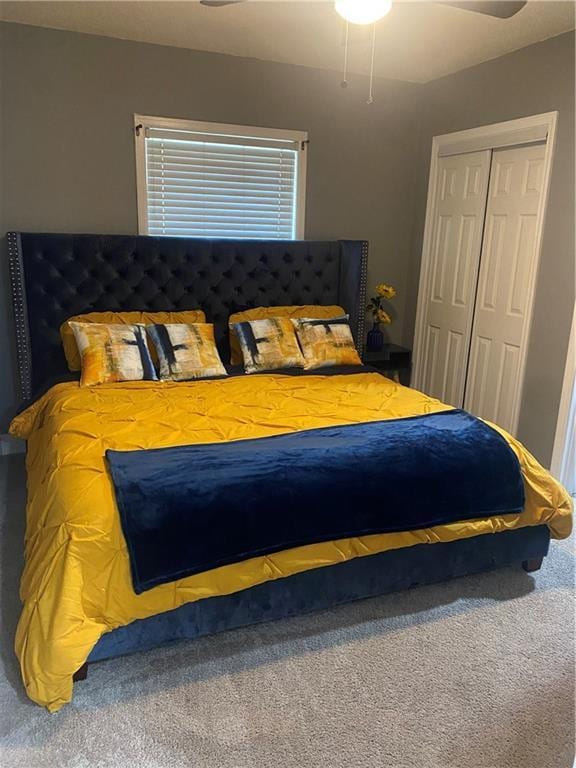 bedroom with a ceiling fan, a closet, and carpet flooring