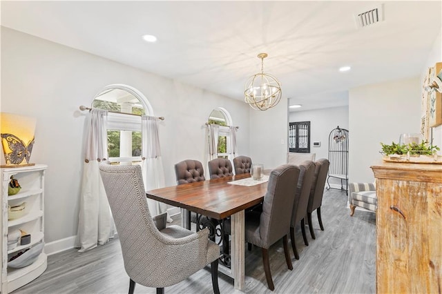 dining area with hardwood / wood-style floors and a chandelier