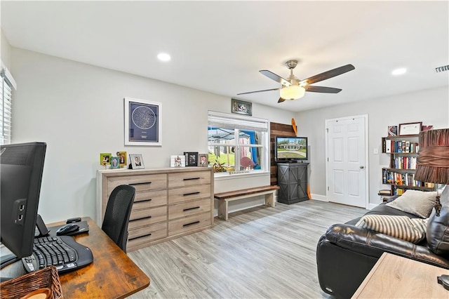 office featuring ceiling fan, light wood-type flooring, and a healthy amount of sunlight