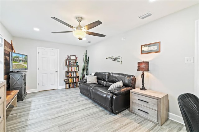 living room with light wood-type flooring and ceiling fan