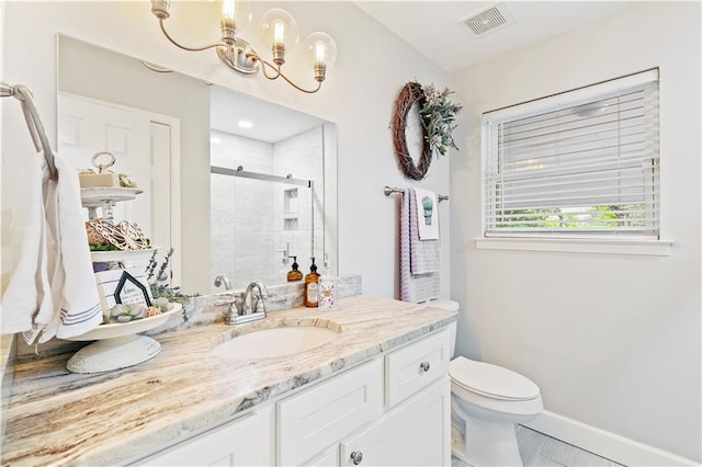 bathroom featuring tile patterned flooring, an enclosed shower, an inviting chandelier, vanity, and toilet