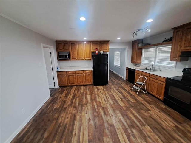 kitchen featuring black appliances, dark wood-style floors, light countertops, and a sink