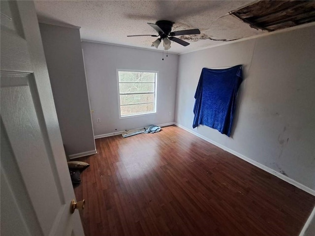 unfurnished bedroom featuring wood finished floors, baseboards, ceiling fan, a textured ceiling, and crown molding