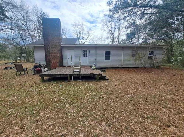 back of property with a deck and a chimney