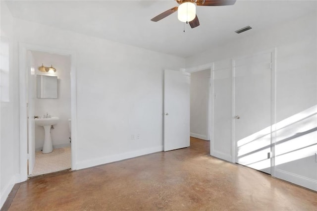 unfurnished bedroom featuring ensuite bathroom, ceiling fan, and concrete floors