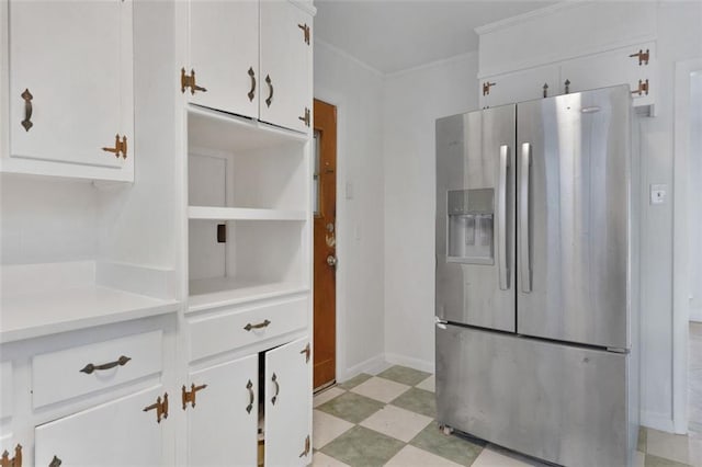 kitchen featuring stainless steel refrigerator with ice dispenser, white cabinetry, and ornamental molding