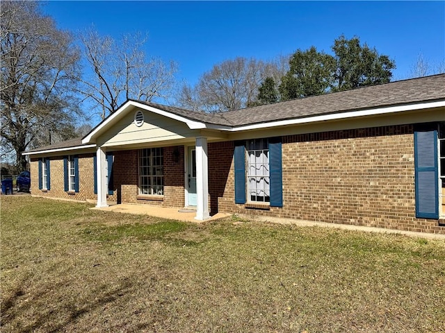 view of front of home featuring brick siding and a front lawn