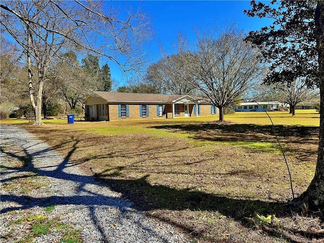 view of front of home with an attached carport, a front lawn, and driveway